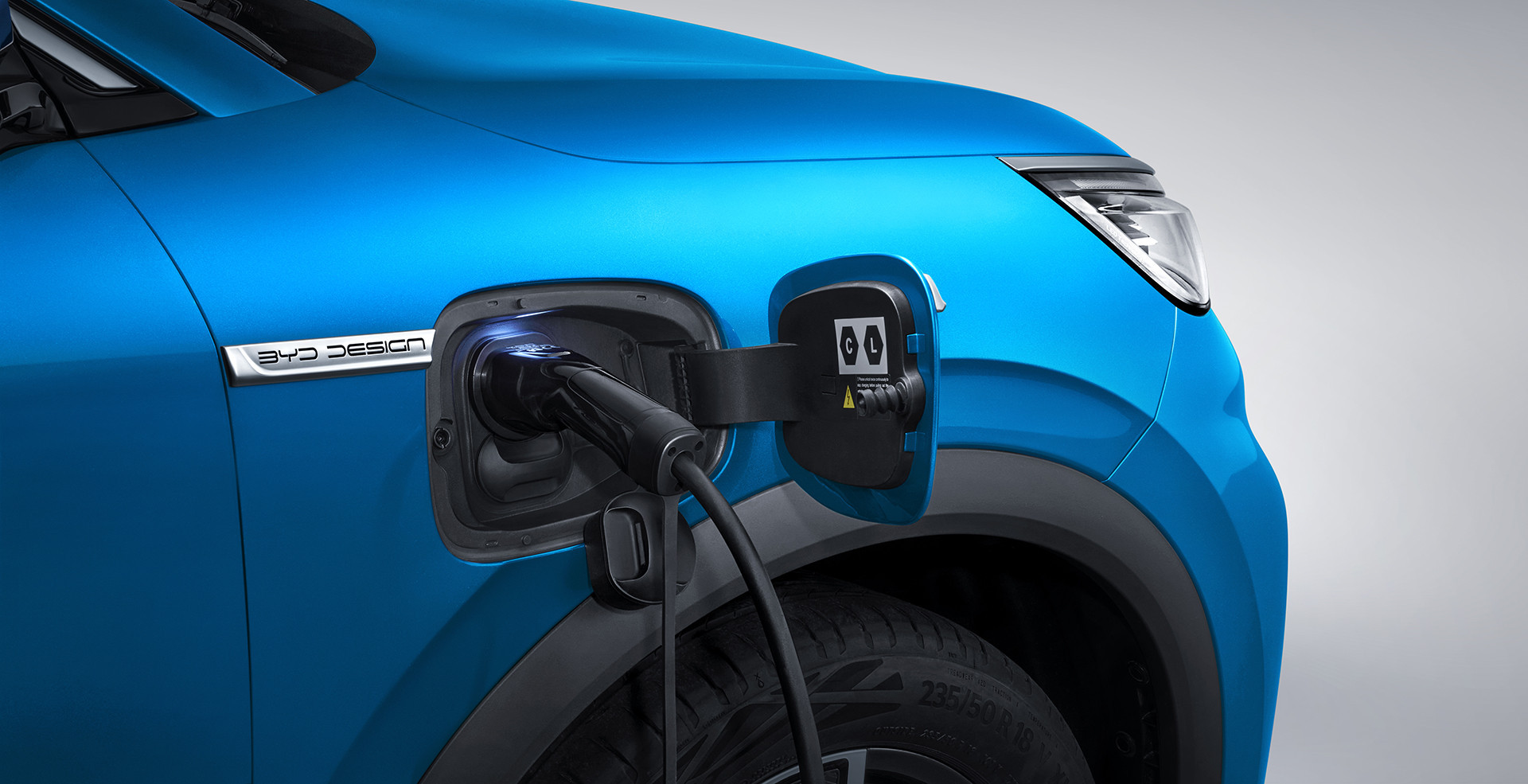 A photograph of a Surfing Blue BYD Atto 3 being charged via a charging cable